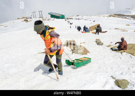 I turisti e gli estrattori di slittino arrampicata neve paesaggio riempito in Gondola Gulmarg Fase 2 / Apharwat picco, Gulmarg, Jammu e Kashmir India Foto Stock