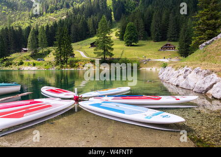 GOSAU, Austria - 4 Luglio 2019: Paddle surf giacente sulla superficie di Vorderer Gosausee lago vicino Banca il 4 luglio 2019 in Gosau, Austria. Foto Stock