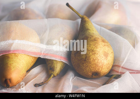 Ridurre la confezione di plastica del concetto. Frutti in autunno in una rete mesh shopping bag. Pere fresche in eco-friendly sacchetti riutilizzabili. Rifiuti di plastica di gestione. Foto Stock