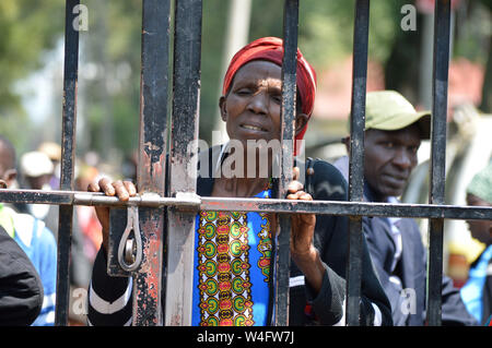 Nakuru, Rift Valley, in Kenya. 22 Luglio, 2019. Una donna colpita dal post poll violenza guarda attraverso un cancello di ferro dopo l Udienza della causa principale di richiedere il risarcimento dei danni è stata sospesa in attesa della conferma dello status di sfollati consiglio direttivo.Il governo è stato accusato per compensare in modo irregolare fake IDP e lasciando quelle innocenti con nulla. Oltre cento mila persone colpite dal Kenya la violenza post elettorale sono stati a languire nella miseria per anni in attesa che il risarcimento dal governo. Kenya 2007-2008 post violenza sondaggio condotto alla morte, spostamenti forzati e Foto Stock