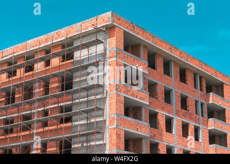 Ponteggio a vuoto in un cantiere con incompiuto edificio incompleto e cielo vuoto come spazio di copia Foto Stock