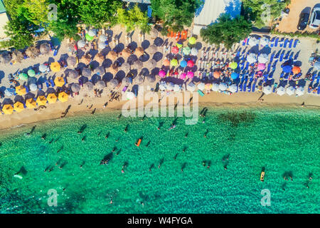 Vista aerea del Aliki spiaggia con ombrelloni colorati, a Thassos Island, Grecia. piscina persone in mare Foto Stock