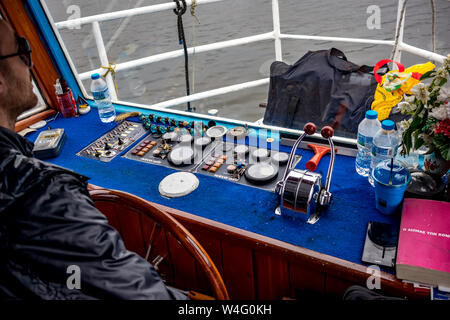 IOANNINA, Grecia - 6 giugno 2019 - Cruscotto di piccoli vecchi crociera turistica traghetto sul lago Pamvotida vicino alla piccola e bella città greca. Torna la vista la mattina all'interno della cabina con sfocate capitano maschio Foto Stock