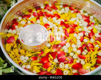 Acqua con profumo tailandese in acqua il bilanciere con fiori colorati petali e garland per il Songkran festival, Thailandia, Vaso con fiori come il gelsomino, ro Foto Stock