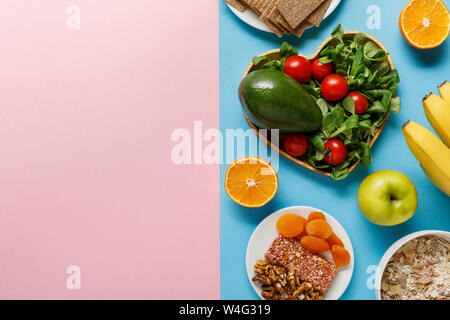 Vista superiore della dieta alimentare sulla blu e sfondo rosa con spazio di copia Foto Stock