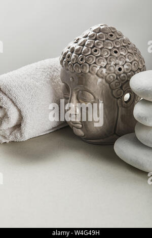 Panno di cotone, pietre, BUDDA STATUETTA sul tavolo bianco isolato su grigio Foto Stock