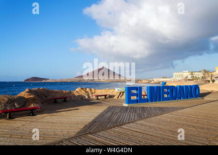 Segno tridimensionale El Medano sulla lunga passeggiata lungo la costa e la spiaggia con il Montana Roja in background, El Medano, Tenerife, Isole Canarie Foto Stock