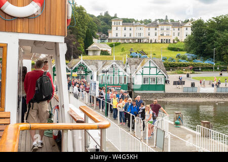 Bowness on Windermere - MV Teal incrociatore vapore arrivando a Bowness Pier e i passeggeri in coda sul molo a bordo - Lake District, Cumbria, England, Regno Unito Foto Stock