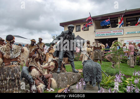 Zulu warriors accanto al drover della statua presso il Royal Welsh showground in Llanelwedd. Visita del re la buona volontà della Nazione Zulu al Royal Welsh Show (RWA) a Builth Wells. Llanelwedd, POWYS, GALLES. Foto Stock