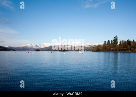 La neve clad Fairfield Horseshoe sopra Ambleside dalla riva del lago Bowness-on-Windermere in una luminosa giornata invernale il Lake District Cumbria Inghilterra England Foto Stock