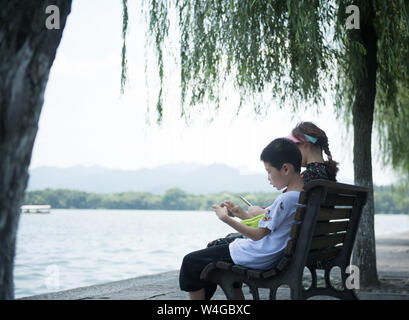 (190723) -- HANGZHOU, luglio 23, 2019 (Xinhua) -- i turisti resto vicino al West Lake in Hangzhou, est della Cina di Provincia dello Zhejiang, 23 luglio, 2019. Onda di Calore continua a colpire Hangzhou fino ai primi di agosto. (Xinhua/Weng Xinyang) Foto Stock