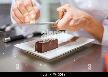 Junior Chef prepairing un dessert, reticolo noce di cocco Foto Stock