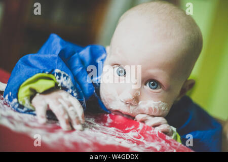 Ritratto di baby boy rendendo pasticcio mentre mangia Foto Stock
