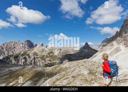 Escursionista femmina guardando a vista, Tre Cime di Lavaredo Zona, parco naturale Tre Cime, patrimonio mondiale Unesco sito naturale, Dolomiti di Sesto, Italia Foto Stock