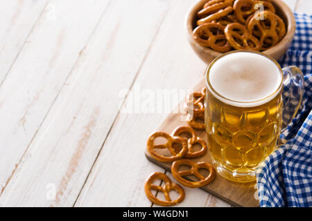 Oktoberfest birra e pretzel su bianco tavolo in legno.Copyspace Foto Stock