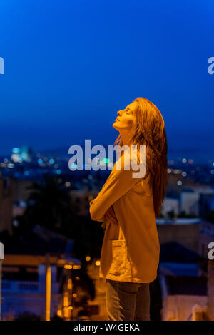 Giovane donna con gli occhi chiusi sul punto di vista al blue ora Foto Stock