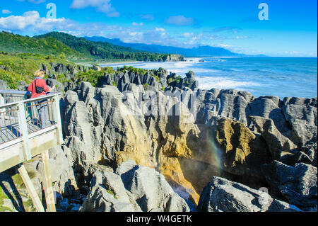 Donna sulla piattaforma di osservazione a Pancake Rocks, Paparoa National Park, Isola del Sud, Nuova Zelanda Foto Stock