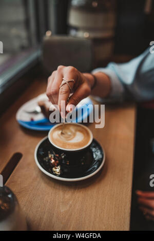 Close-up di donna con un cappuccino in un caffè Foto Stock