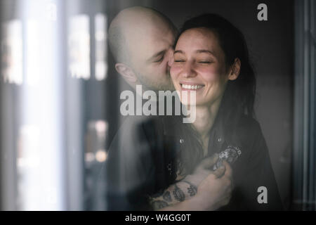 Matura in amore dietro il vetro di finestra Foto Stock