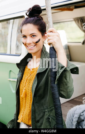 Giovane donna con lancia e facepaint davanti al suo camper Foto Stock
