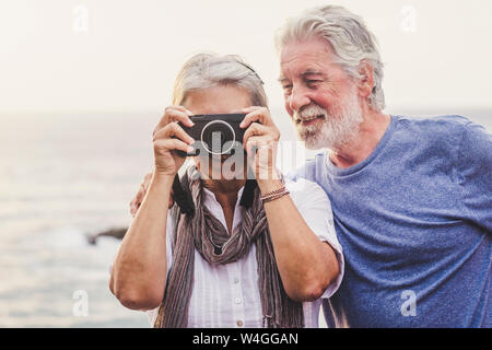 Viaggiare Coppia senior, scattare foto al mare Foto Stock