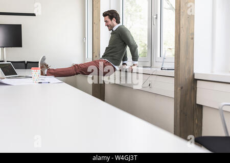 Giovane imprenditore prendendo una pausa, stirando le gambe Foto Stock