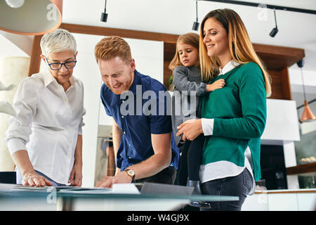 Famiglia shopping per una nuova cucina nella showroom guardando papers Foto Stock