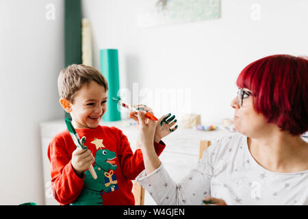 Madre e figlio divertirsi mentre si fanno i mestieri a casa Foto Stock