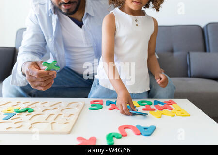 Padre e figlia gioca con alfabeto gioco di apprendimento a casa Foto Stock