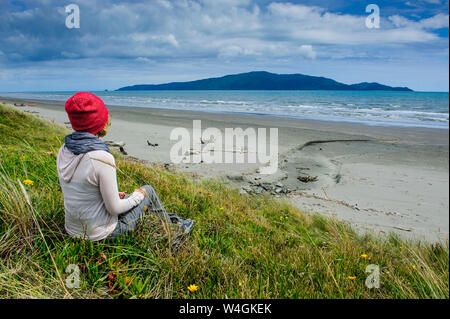 Donna in appoggio a Foxton beach, la Costa di Kapiti, Isola del nord, Nuova Zelanda Foto Stock