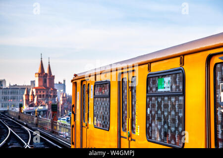 Il treno sulla ferrovia sopraelevata nella parte anteriore del ponte Oberbaum al crepuscolo, Berlino, Germania Foto Stock