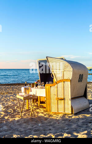 Tavola apparecchiata e con cappuccio sedie a sdraio sulla spiaggia la sera, Heiligendamm, Germania Foto Stock
