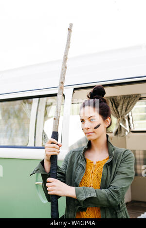 Giovane donna con lancia e facepaint davanti al suo camper Foto Stock