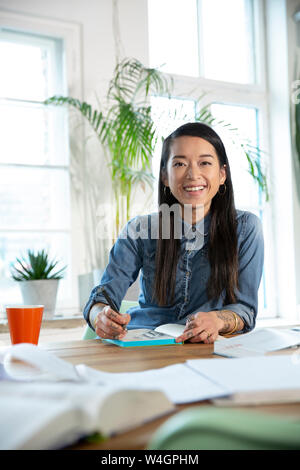 Ritratto di donna felice lavorando a tavola in office Foto Stock