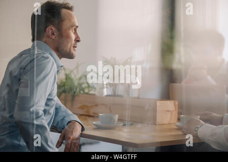 Imprenditore di successo in seduta coffee shop, avente una riunione Foto Stock