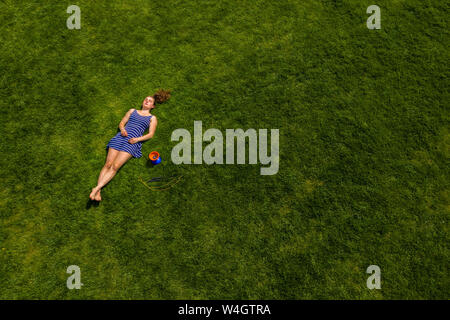 Vista aerea di una giovane donna sdraiata su un prato Foto Stock