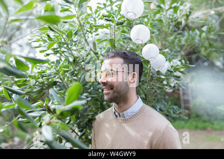 Uomo sorridente in giardino Foto Stock