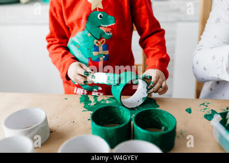 Bambino facendo artigianato pittura rotoli di cartone Foto Stock