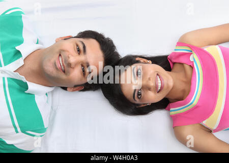 Giovane giacente sul letto e sorridente Foto Stock
