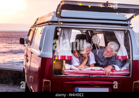 Coppia senior in viaggio in un'annata van, giacente in boot Foto Stock