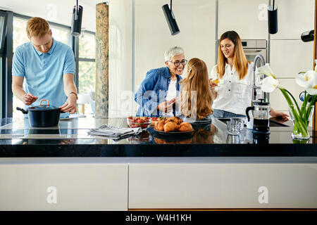 Tre genaration famiglia preparare il cibo in cucina Foto Stock