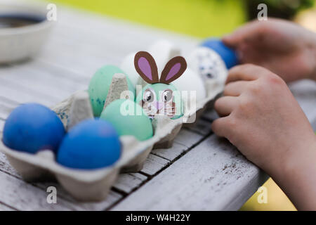 Close-up di ragazza decorazione di uovo di pasqua sul tavolo da giardino Foto Stock