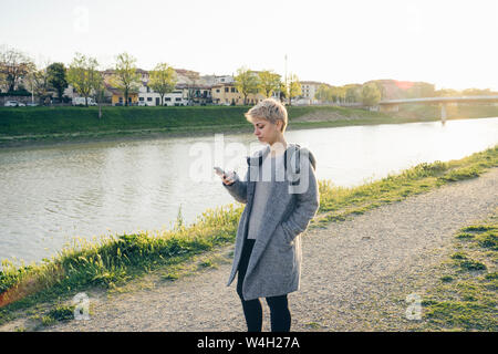 Giovane donna tramite telefono cellulare all'aperto Foto Stock