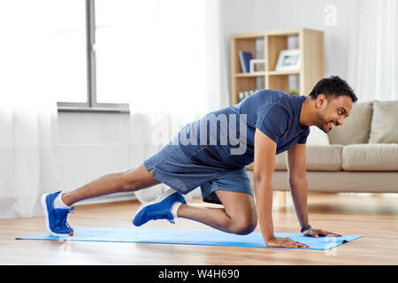 L'uomo facendo in esecuzione plank esercizio a casa Foto Stock