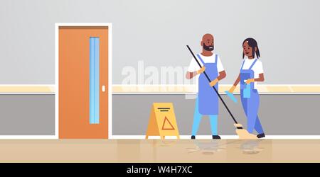 Giovane pulitori in uniforme lavorando insieme il servizio di pulizia concetto americano africano uomo donna portieri utilizzando mop spray flacone di plastica moderna clinica Illustrazione Vettoriale