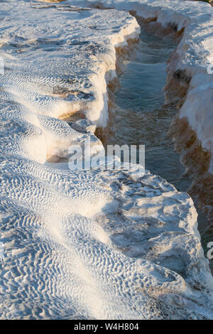 Turchia: acqua fluente da hot springs sulle terrazze di travertino di Pamukkale (Castello di cotone), un sito naturale di roccia sedimentaria depositato da acqua Foto Stock
