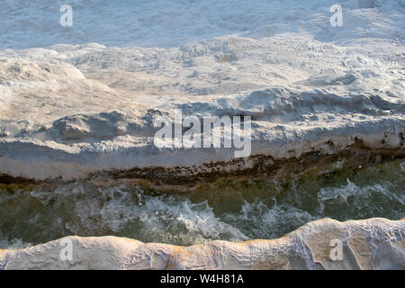 Turchia: acqua fluente da hot springs sulle terrazze di travertino di Pamukkale (Castello di cotone), un sito naturale di roccia sedimentaria depositato da acqua Foto Stock