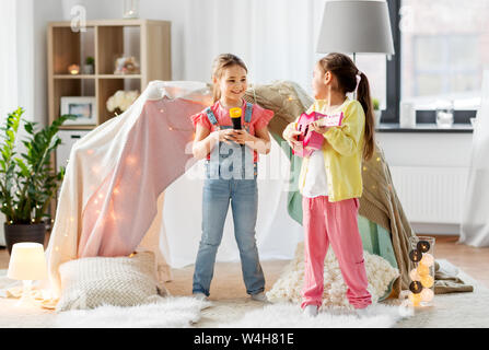 Le ragazze con la chitarra e il microfono a giocare a casa Foto Stock