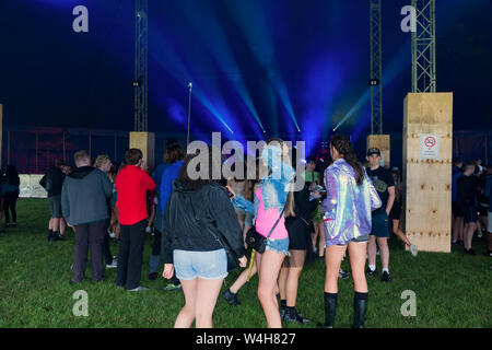 Gli adolescenti ascoltando musica rave in una grande marca in un outdoor festival di musica Foto Stock