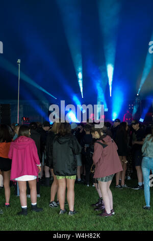 Gli adolescenti ascoltando musica rave in una grande marca in un outdoor festival di musica Foto Stock